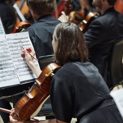 Cellist making notes on their sheet music